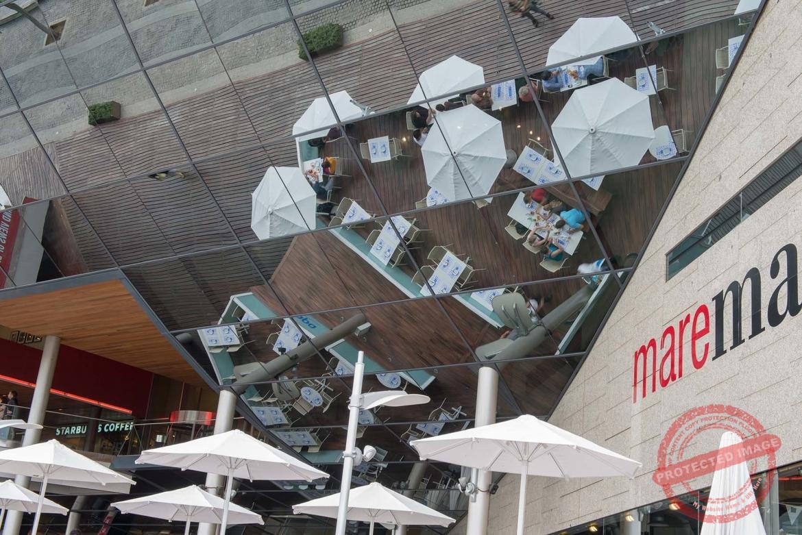 Odbicia białych parasolii w zabudowie centrum handlowegow Port Vell w Barcelonie