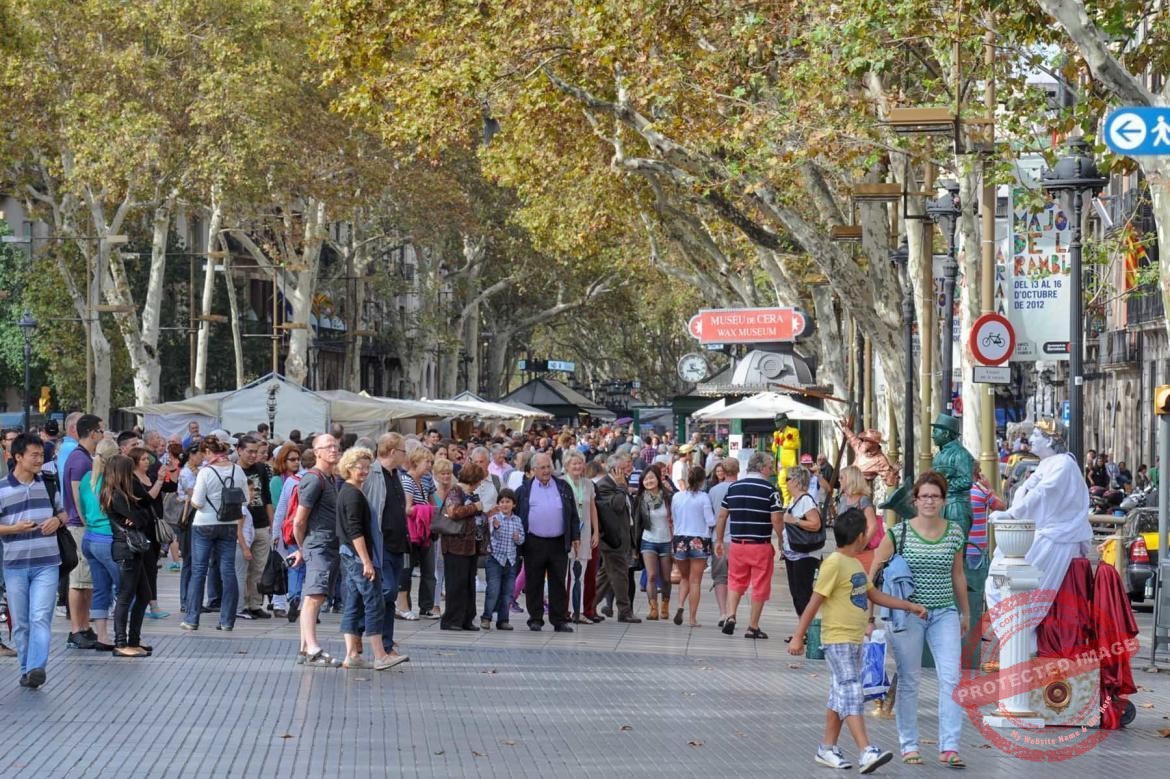 Turyści oraz uliczni artyści na La Rambla w Barcelonie