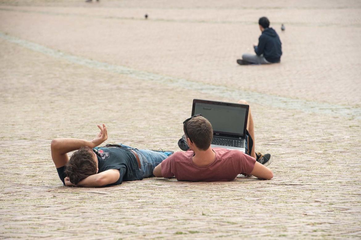 Ludzie siedzący i odpoczywający na Piazza del Campo w Sienie