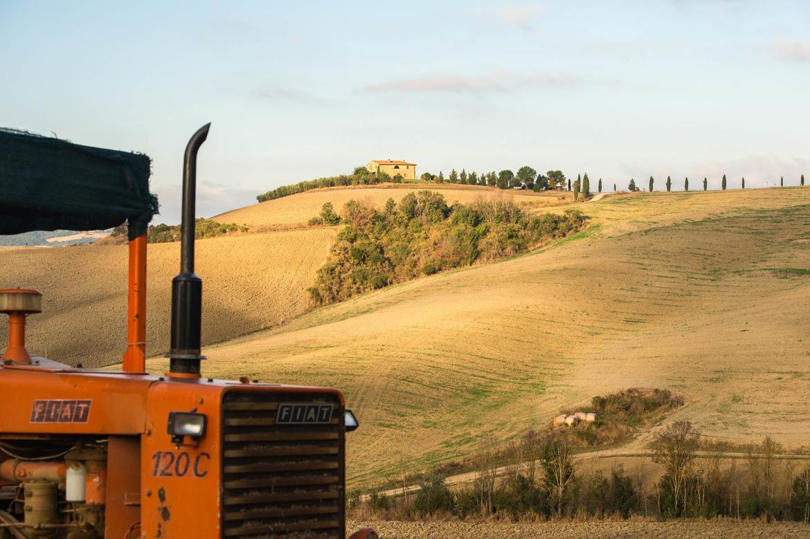 Czerwony traktor na toskańskich polach w ololicach Val d'Orcia