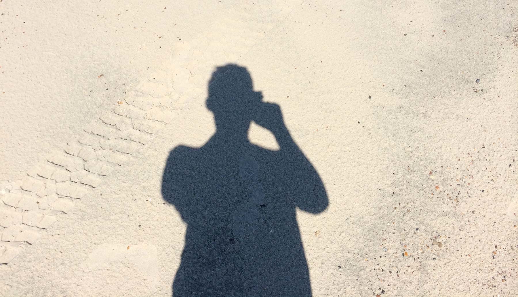 Cień człowieka na plaży w słoneczny dzień