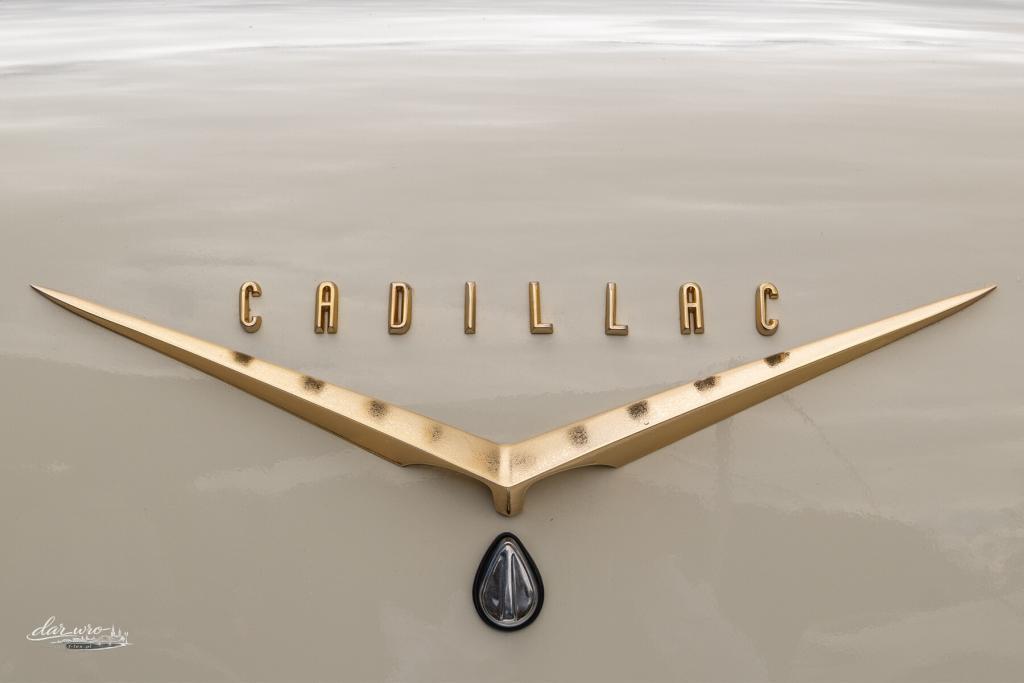 Detal klasycznego samochodu Cadillac z widocznym emblematem marki